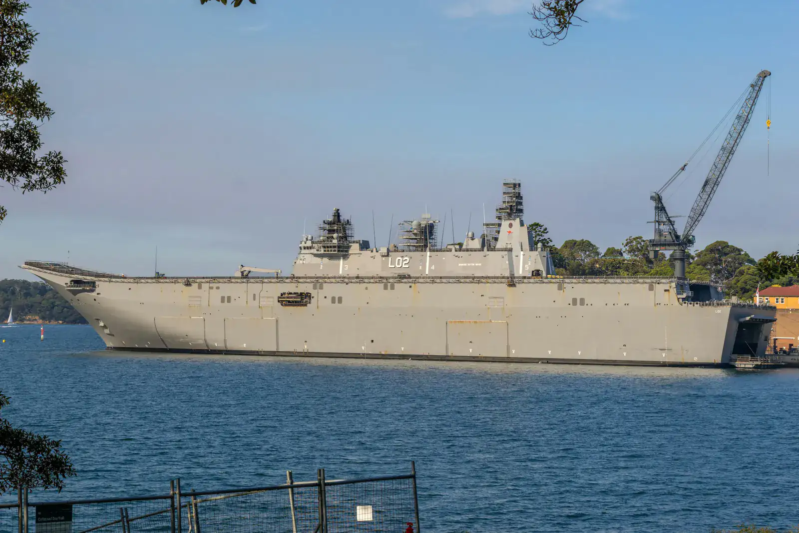 Royal Australian Navy amphibious ship HMAS Canberra moored beside a dockside crane at Garden Island, Sydney Harbour